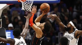 Detroit Pistons guard Cade Cunningham, center, is defended on his shot by Brooklyn Nets forward Dorian Finney-Smith (28) forward Royce O'Neale, right, during the second half of an NBA basketball game, Tuesday, Dec. 26, 2023, in Detroit. (AP Photo/Duane Burleson)