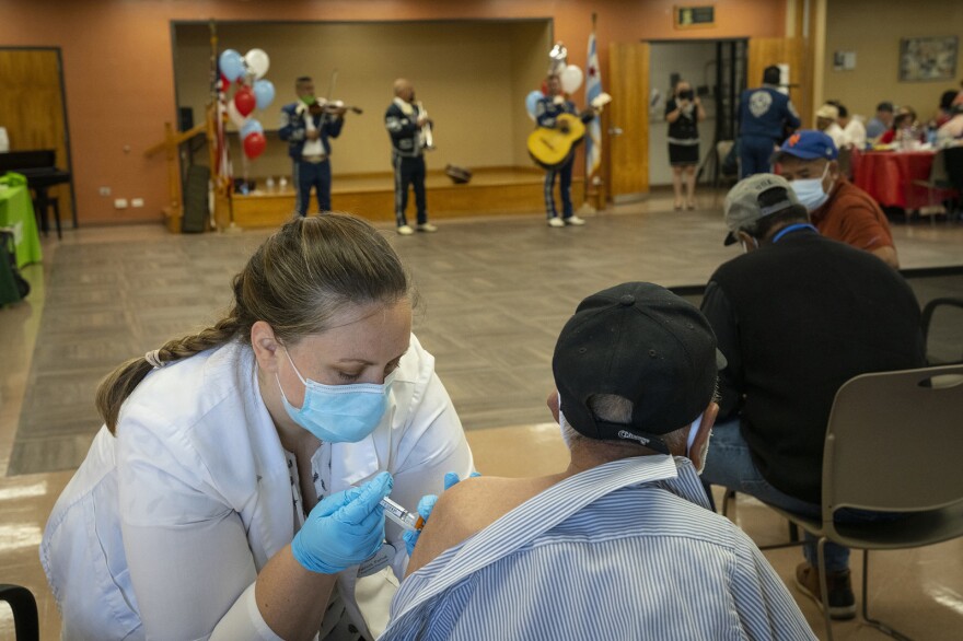 A pharmacist administers the newest COVID-19 vaccine during a clinic for seniors at the Southwest Senior Center earlier this month in Chicago.