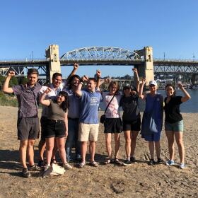 Group of people raising their hands on a beach. 