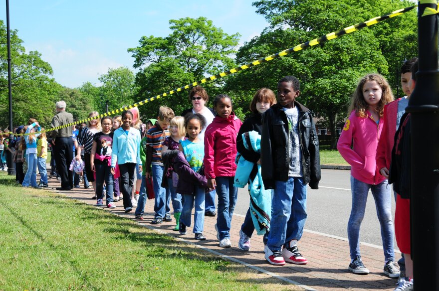 children lined up on a sidewalk 