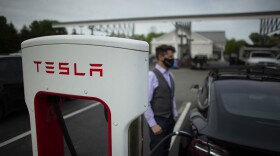 Ben Rich charges his Tesla vehicle at a super charging station in New Jersey. (KENA BETANCUR/AFP via Getty Images)