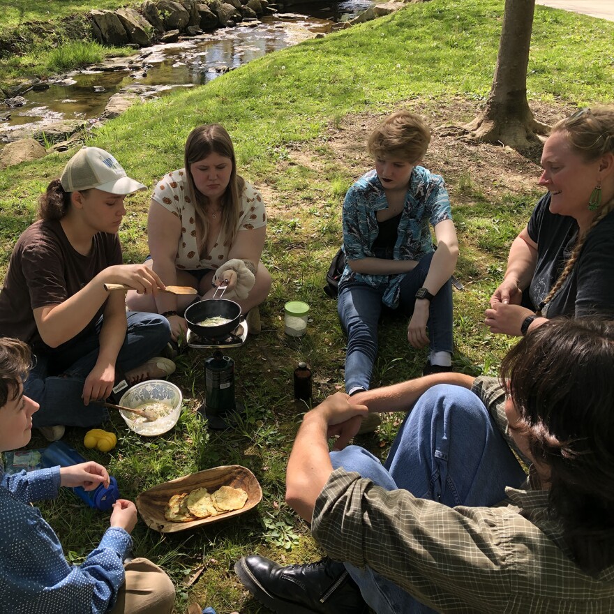 Monique Philpot (far right) talks with students in her Wild Edible Plant course on the IU campus, as they prepare crepes on a camp stove featuring wild onion and edible flowers. The class is offered through the Collins Living Learning Center.