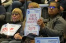 Cincinnati Public School teachers hold signs during a 2025 Board of Education meeting.