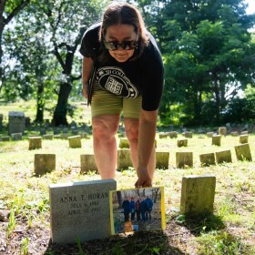 Sherill Baldwin holds a photo of reunited family members of Anna Horan next to her headstone in Blake Street Cemetery in New Haven on July 2, 2026.