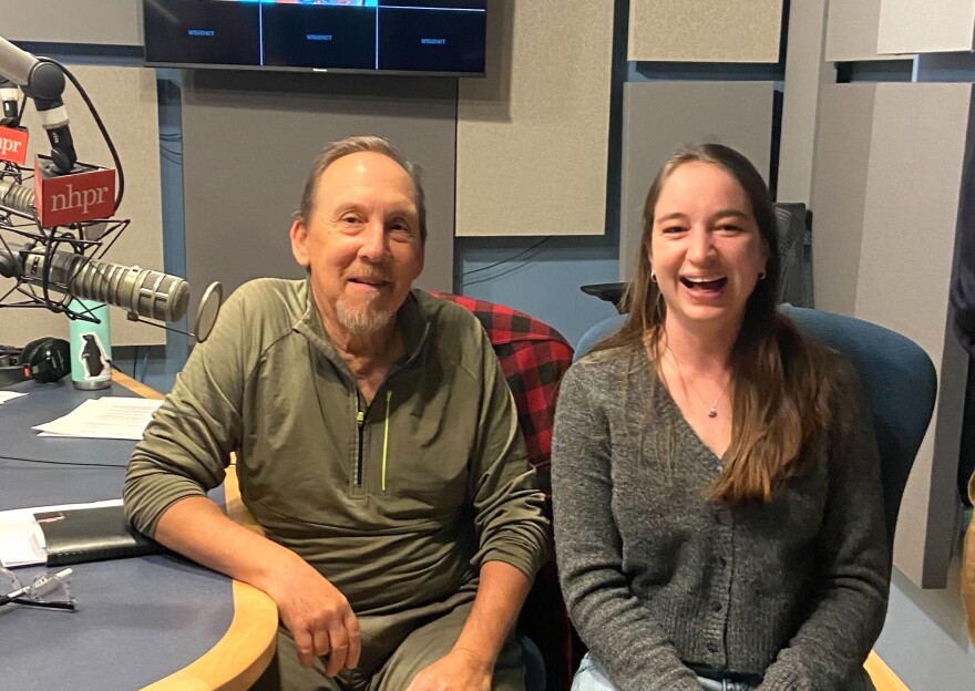 A man and a woman sit next to each other in a recording studio.
