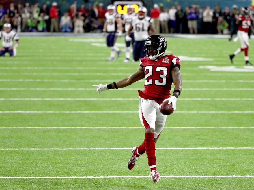 Falcons defensive back Robert Alford scores an 82-yard touchdown after picking off a pass by Patriots quarterback Tom Brady. The score gave the Falcons a daunting lead.