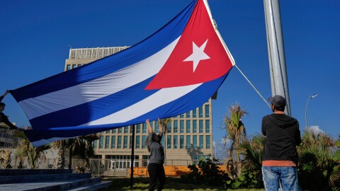 Workers fly the Cuban flag at half-mast at the Anti-Imperialist Tribune near the U.S. embassy in Havana, Cuba, Monday, Jan. 5, 2026, in memory of Cubans who died two days before in Caracas, Venezuela during the capture of Venezuelan President Nicolas Maduro by U.S. forces. (AP Photo/Ramon Espinosa)