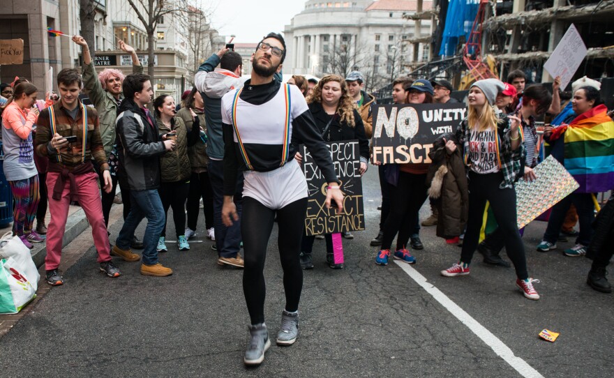 Firas Nasr dances amongst a group of LGBT-affiliated protesters as they block one of the entries to the presidential inauguration parade route.