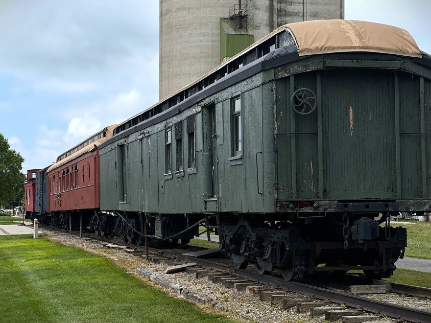 Four railcars connected on a stretch of track.