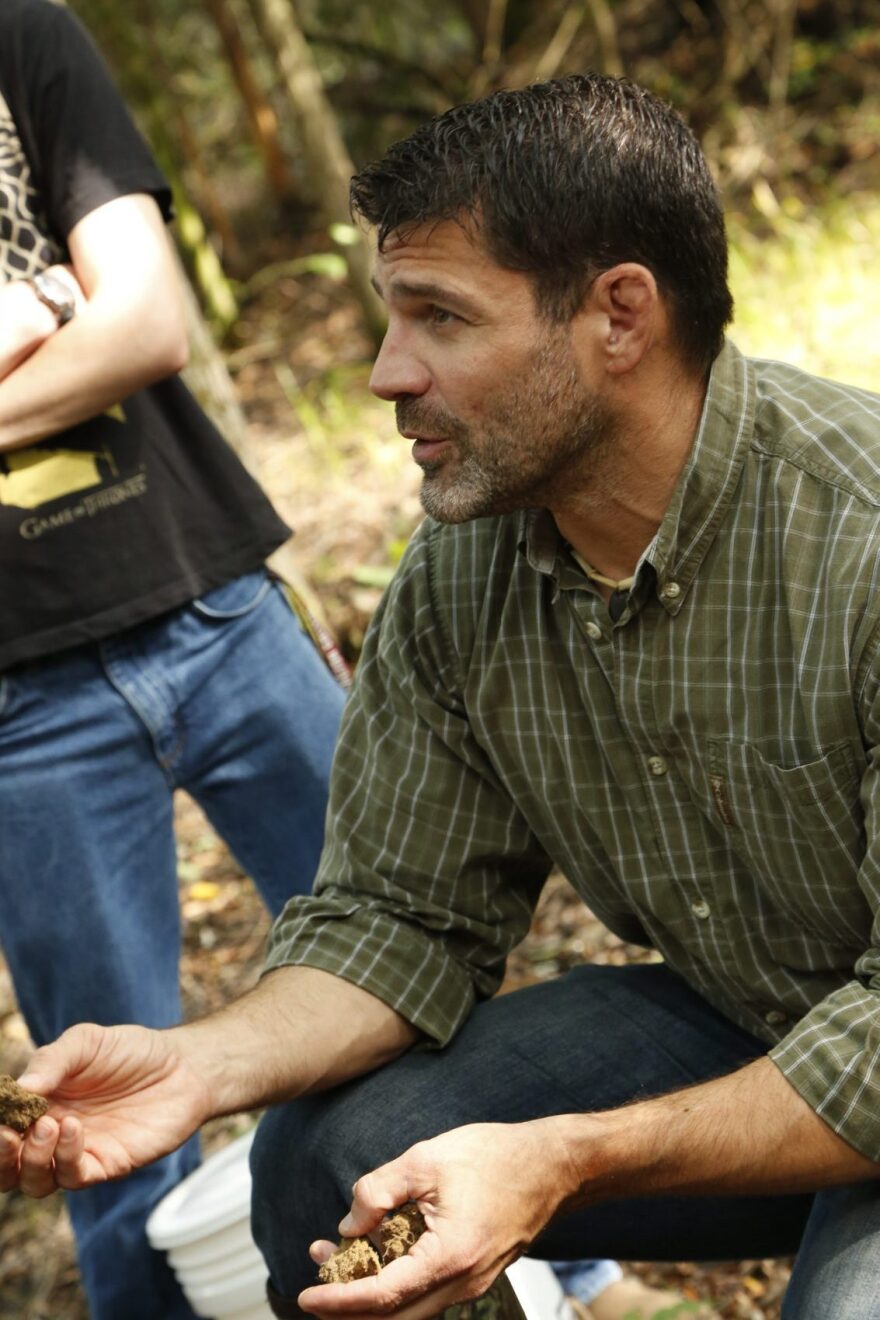 Bill Schindler helps students identify good sources of clay that they will use to create vessels that will be fired in an open pit fire and used to transport food. (Courtesy Washington College)