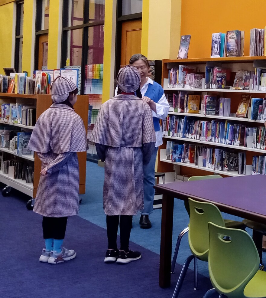 Belley and Emma Barrett from Orange, Massachusetts, speak with friend Qing Chen, at the Hadley Public Library. The girls held a reading of their book, "Sister Detectives." It's written in English and Chinese. Liu, who is a professional translator, helped with the book.