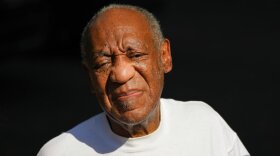 File-This June 30, 2021, file photo shows Bill Cosby reacting outside his home in Elkins Park, Pa., after being released from prison. The lead prosecutor in Cosby's sex assault case believes the Pennsylvania Supreme Court overstepped its power in reversing the comedian's conviction and added "fuel on the fire' when the chief judge gave a weekend television interview, and appeared to misstate the key issue in the appeal. Chief Judge Max Baer accused prosecutors of a "reprehensible bait and switch" in arresting Cosby in 2015 despite what he called the certain existence of a 2005 non-prosecution agreement. (AP Photo/Matt Slocum, File)