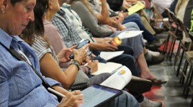 Attendees take notes during an update meeting July 21, 2026, about North Star Manganese's proposed mining project in Emily.