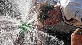  A person cools off with his head in a water spray 