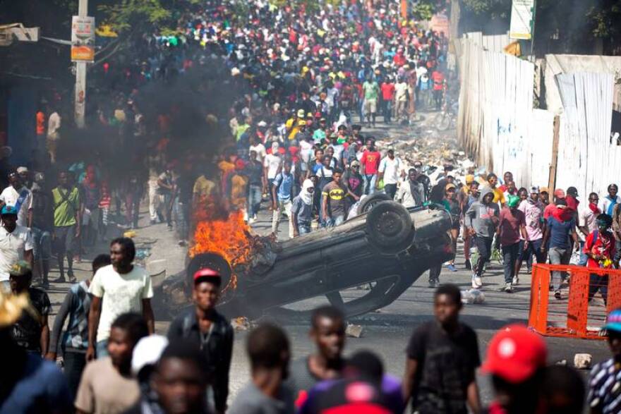 An overturned car burns in Port-au-Prince this week during protests aimed at Haitian President Jovenel Moise.