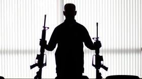 An ATF agent poses with homemade rifles, or "ghost guns," at an agency field office in Glendale, Calif. There's a growing industry of companies that sell gun kits, instructions and do-it-yourself components online to help people build their own guns.