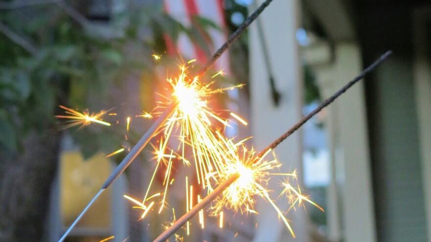 sparklers sparkle in front of US flag 