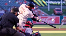 Los Angeles Angels' Jo Adell, center, hits a two-run home run as St. Louis Cardinals catcher Iván Herrera, right, and home plate umpire Mark Ripperger watch during the first inning of a baseball game Tuesday, July 21, 2026, in Anaheim, Calif.  