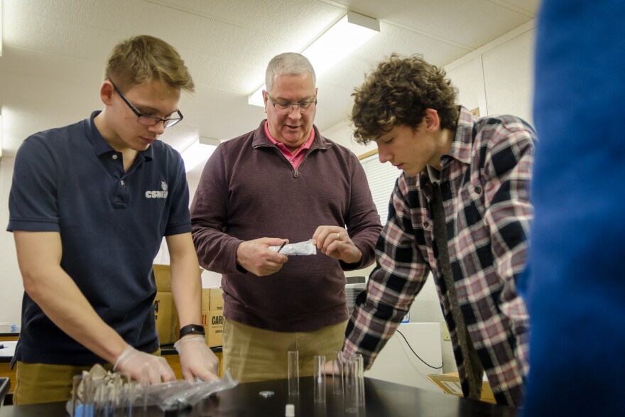 Mark Schisler, a biology teacher, helps students prep a lab at Collegiate School of Medicine and Bioscience. Schisler was a chiropractor before switching to teaching. 