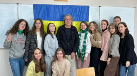 Bob Wood, a retired teacher from Muskegon,  stands with eleven students in a classroom at the Ukrainian Catholic University in Lviv.  