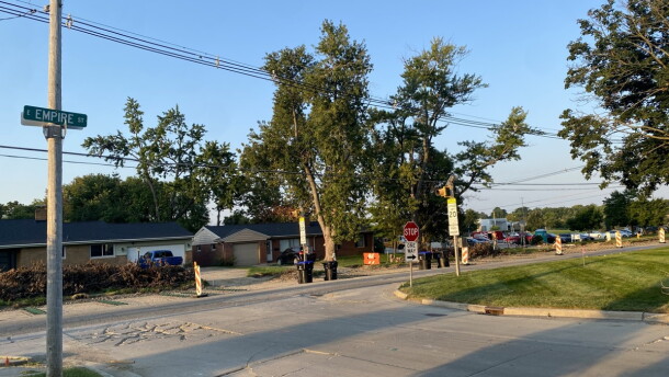 Landscape of Empire Street with construction cones along the roadside. Bloomington High School can be seen in the distance.