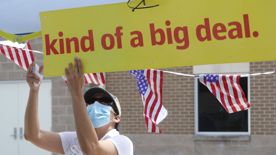 U.S. Census Bureau worker Marisela Gonzales adjusts a sign at a walk-up counting site for the 2020 census in Greenville, Texas, in July. [LM Otero / AP]