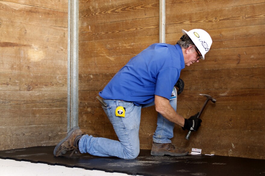 Lee Ferguson, 63, the one full-time maintenance worker at the Alachua County Agriculture and Equestrian Center, installs new padding in the barn stalls on Feb. 11, 2021. The installation is in preparation for the upcoming Youth and Livestock Fair on March 5, 2021. Ferguson has worked on the land since the 1990s. (Julia Coin/WUFT News)