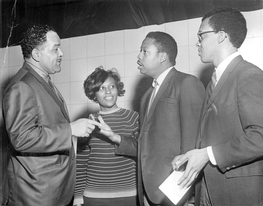 Four people talk with each other in this 1968 photo.