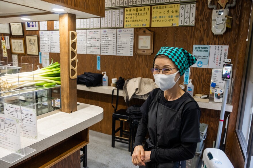 Onigiri Bongo owner Yumiko Ukon stands in front of a wall listing the 50-plus fillings that diners can order for their rice balls.