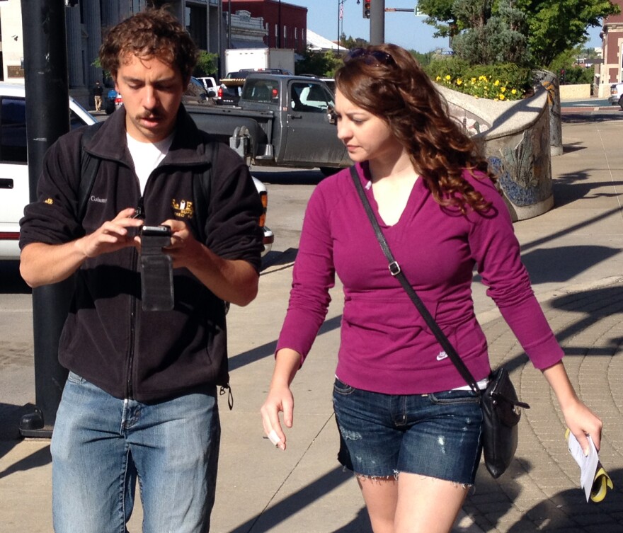 MU senior Max Smith, left, uses his smartphone to navigate around Columbia with senior Amanda Vanslyke. The students are particpating in the university's "REBOOT Mizzou" project, which teaches sustainable practices through a game format.