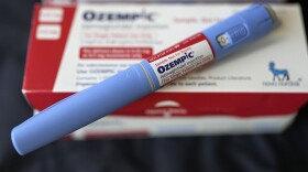 Blue pen with red cap on box