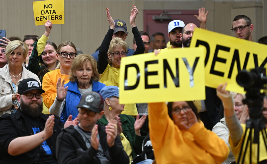 Community members hold "deny" signs during an Archbald Borough Council meeting.