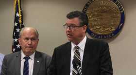 Alaska Gov. Bill Walker watches Alaska Gasline Development Corporation President Keith Meyer talk to reporters during a press conference on March 5, 2018, in Anchorage, Alaska. (Photo by Victoria Petersen/Alaska Public Media)
