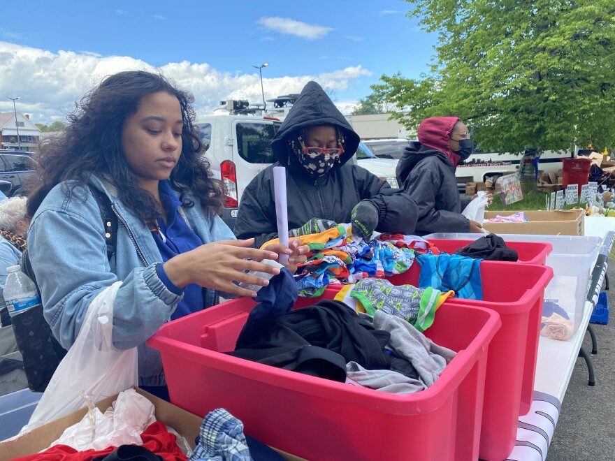 Volunteers with the Bethesda World Harvest International Church sort through boxes of donated clothes to hand out to members of the community.