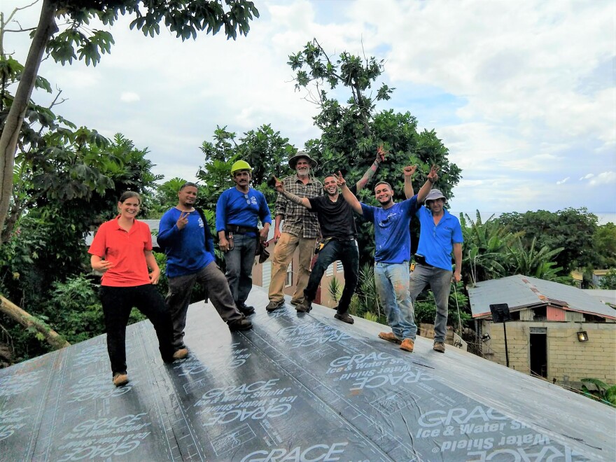Johann Zimmerman (center, in plaid) with a crew from the organization AMPI in Puerto Rico, celebrating the completion of sheathing a hurricane-resistant roof shortly before a storm.