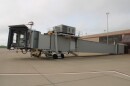 A picture of an airport boarding gate, not attached to a plane and not in operation.