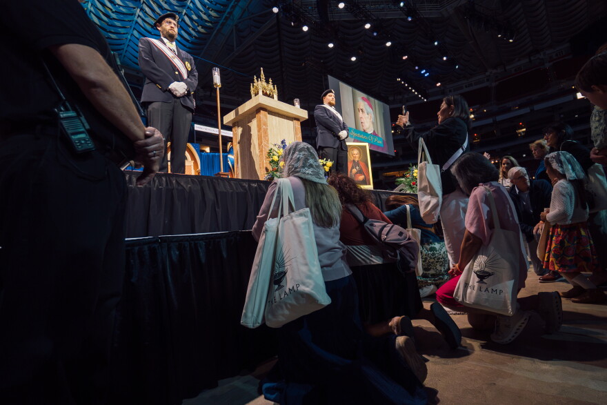 Faithful kneel in prayer before a reliquary containing a portion of the late Archbishop Fulton J. Sheen's jawbone after of his beatification Mass on Thursday in downtown St. Louis.