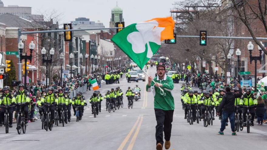 A man carries a shamrock flag on West Broadway Street in South Boston, Mass., during the 2017 St. Patrick's Day parade there.