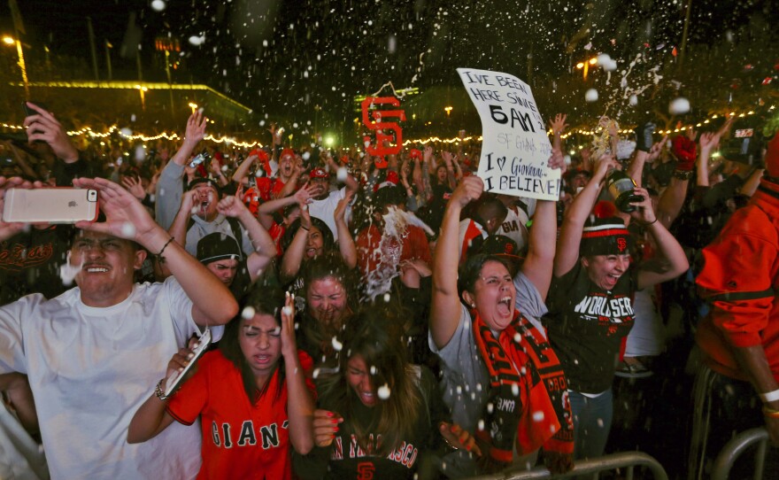 Fans celebrate the Giants' victory during a television-viewing event at the Civic Center in San Francisco.