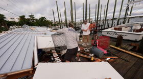 People retrieve belongings from a collapsed boat house in the aftermath of Hurricane Isaias in Destin, Fla., Saturday, Oct. 10, 2026. (AP Photo/Gerald Herbert)