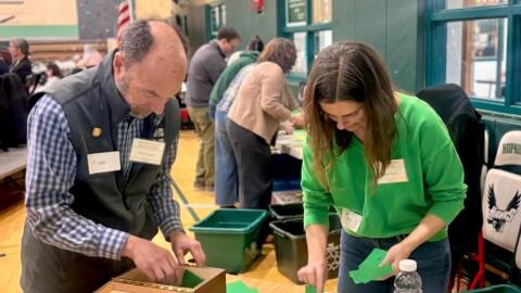 Ken Traum and Andrea Kane count the ballots cast for Hopkinton’s school district’s operating budget.