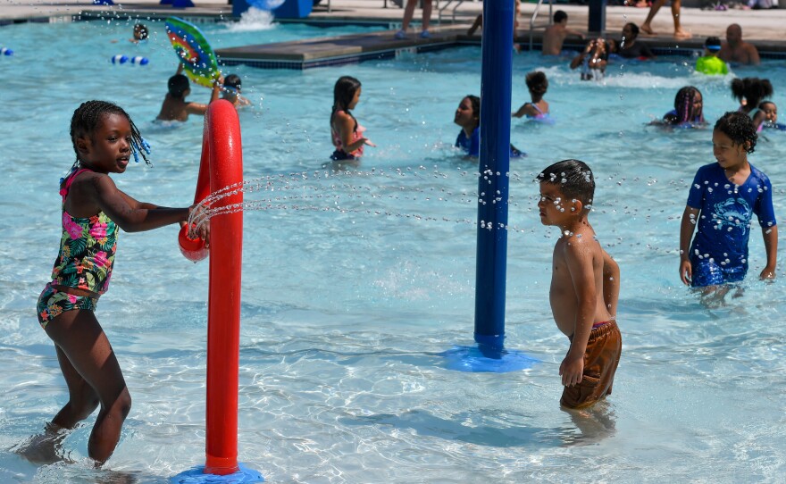 Hayven McGrue, 6, moves a sprinkler while playing at the Weston Field's pool.