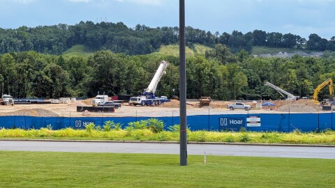 Construction equipment are spaced out across a dirt field where a proposed hyperscale data center is being built.