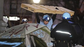 A U.S. Park Police officer removes a wooden structure from an Occupy D.C. protester's tent at McPherson Square in Washington, D.C., on Saturday.