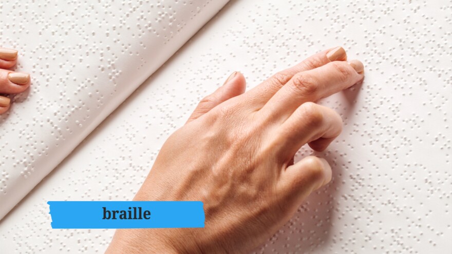 fingers on a page of Braille