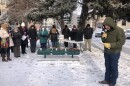 A crowd stands on the snowy Yellowstone County Courthouse lawn as a man reads a prayer