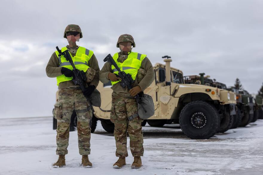 In a photo released by the Minnesota National Guard, service members model the yellow vests they were issued to distinguish them from other agencies. The National Guard obscured the faces of the troops pictured.