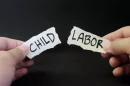  A person tears a labor with the words "Child Labor"