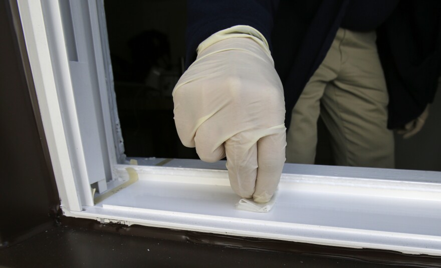 Cuyahoga County Board of Health lead risk assessor Tom Barsa swipes a windowsill for lead Thursday, April 4, 2013, in Lakewood, Ohio.