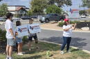 Volunterrs for the Brandon Herrera congressional campaign give away political signs.